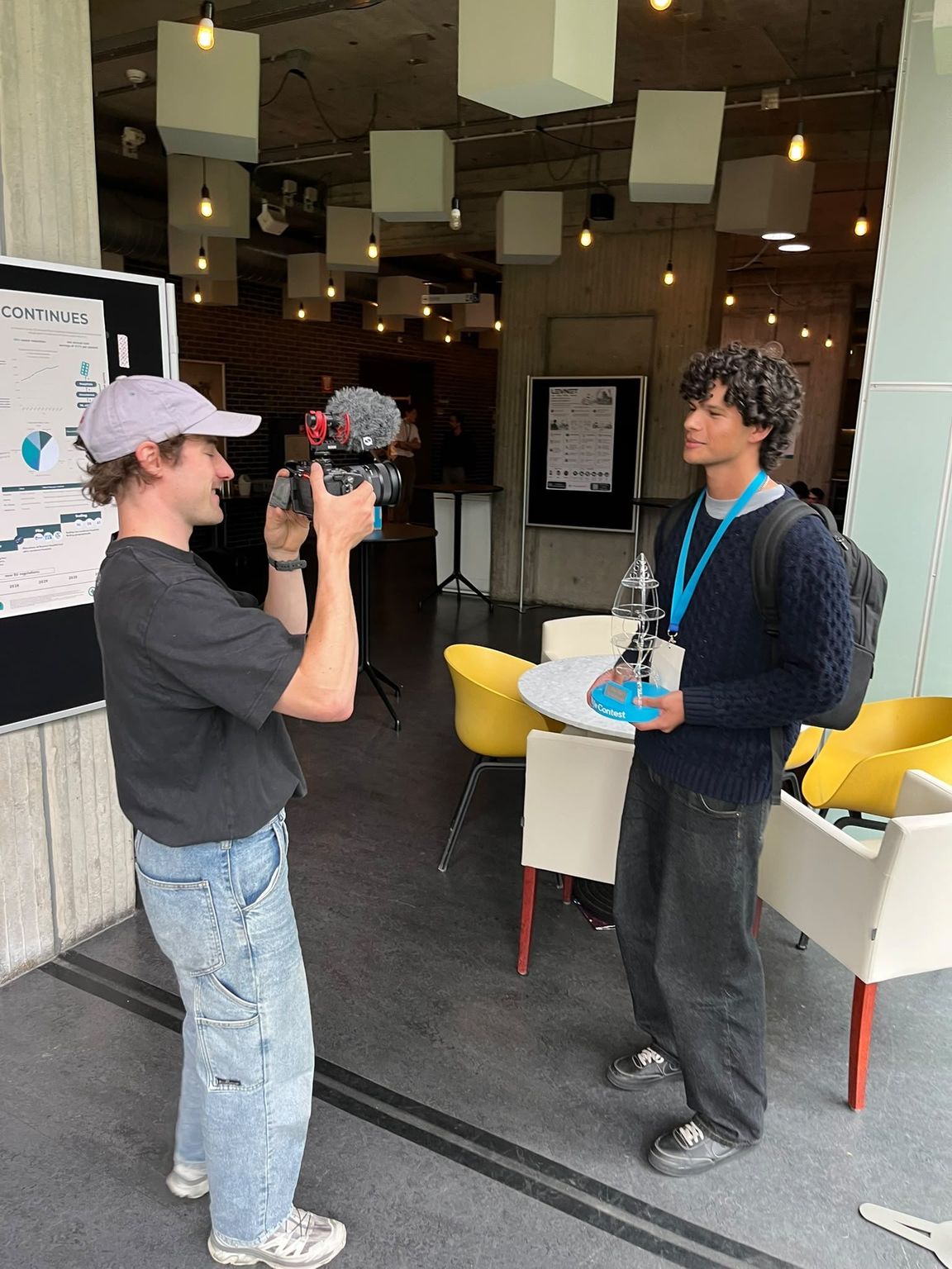 Lucas interviewed on camera, holding the TU/e Contest trophy